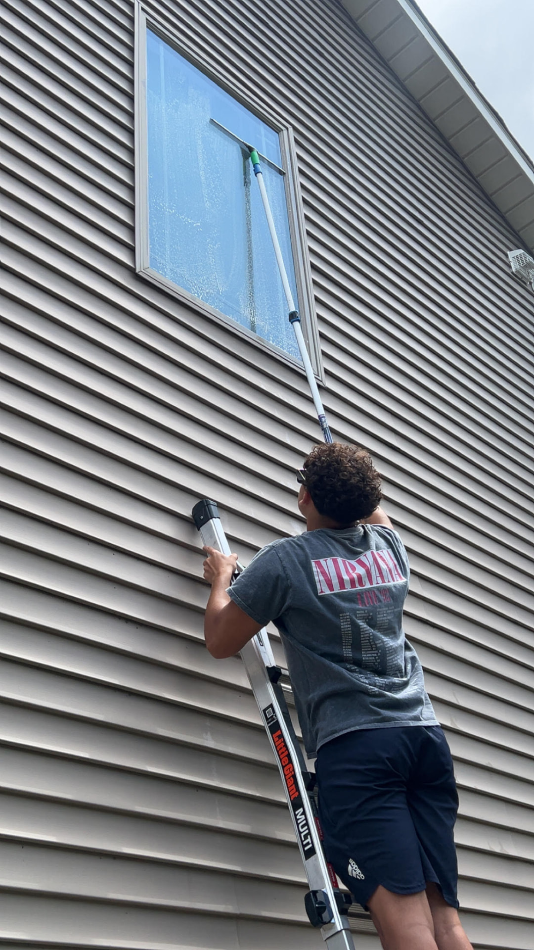 Loyal Home Services technician cleaning a second-story window in Walworth County