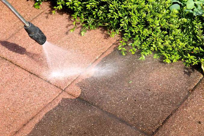 Pressure washer restoring a residential concrete driveway
